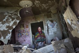 FOR USE AS DESIRED, YEAR END PHOTOS - FILE - Zinaida Patskan, 80, stands in her destroyed house following a shelling from Ukrainian government forces in Semyonovka village near the major highway which links Kharkiv, outside Slovyansk, Ukraine, Thursday, May 22, 2014. (AP Photo/Alexander Zemlianichenko, FILE)