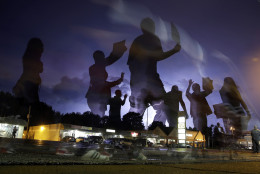 FOR USE AS DESIRED, YEAR END PHOTOS - FILE - Protesters march in the street as lightning flashes in the distance in Ferguson, Mo. on Wednesday, Aug. 20, 2014. On Aug. 9, 2014, a white police officer fatally shot Michael Brown, an unarmed black 18-year old, in the St. Louis suburb. (AP Photo/Jeff Roberson, File)