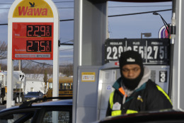 As a worker pumps gas, a sign displays that regular is $2.29-a-gallon, Friday, Dec. 12, 2014, in Neptune, N.J. Motorists are now seeing prices under $3 a gallon for the first time in four years, which also means that gas stations are paying less for the fuel, too. (AP Photo/Mel Evans)