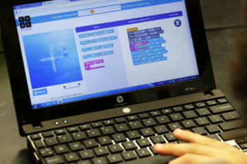 Hands keying in info on laptop.