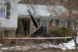 The wreckage of a small private jet sits in a driveway after crashing into a neighboring house in Gaithersburg, Md., Monday, Dec. 8, 2014. A woman and her two young sons inside the home and three people aboard the aircraft were killed, authorities said. (AP Photo/Jose Luis Magana)