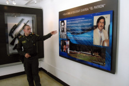 This Dec. 31, 2013 photo shows Kevin Riano explaining an exhibit about Pablo Escobar at the National Police Museum in Bogota, Colombia. Escobar, the notorious drug kingpin, was assassinated in a police ambush in Medellin in 1993. The museum offers free tours in English led by young Colombians like Riano who are fulfilling a required national service stint. (AP Photo/Beth J. Harpaz)