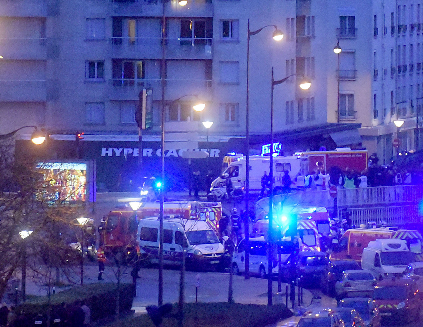  French firemen and emergency doctors enter a kosher deli during a hostage situation at Port de Vincennes on January 9, 2015 in Paris, France. According to reports at least five people were taken hostage in a kosher deli in the Port de Vincennes area of Paris. A huge manhunt for the two suspected gunmen in Wednesday's deadly attack on Charlie Hebdo magazine has entered its third day. (Photo by Antoine Antoniol/Getty Images)