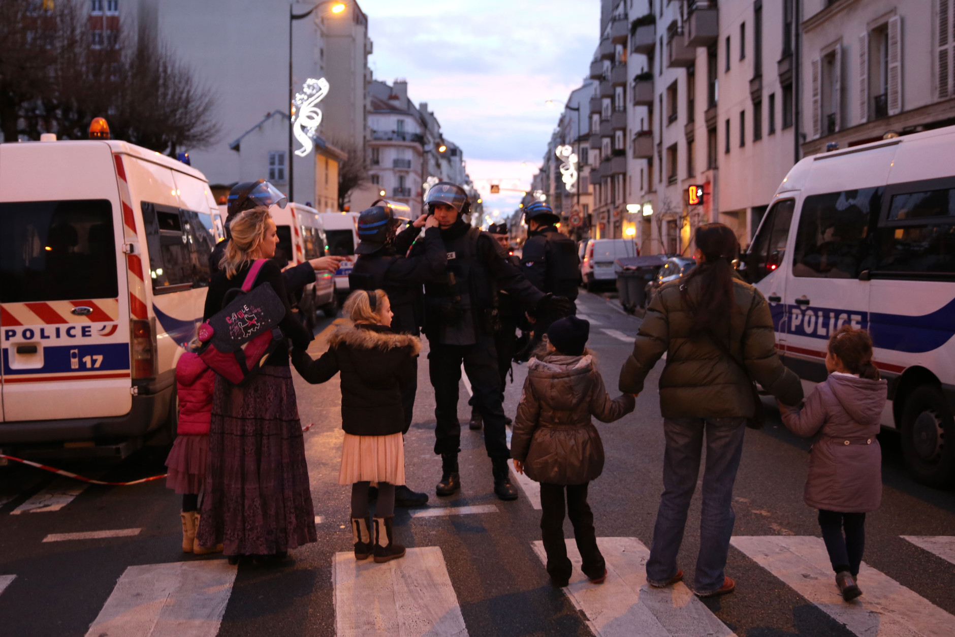  Police escort women and children as they mobilize at the hostage situation at Port de Vincennes on January 9, 2015 in Paris, France. According to reports at least five people have been taken hostage in a kosher deli in the Port de Vincennes area of Paris. A huge manhunt for the two suspected gunmen in Wednesday's deadly attack on Charlie Hebdo magazine has entered its third day. (Photo by Dan Kitwood/Getty Images)