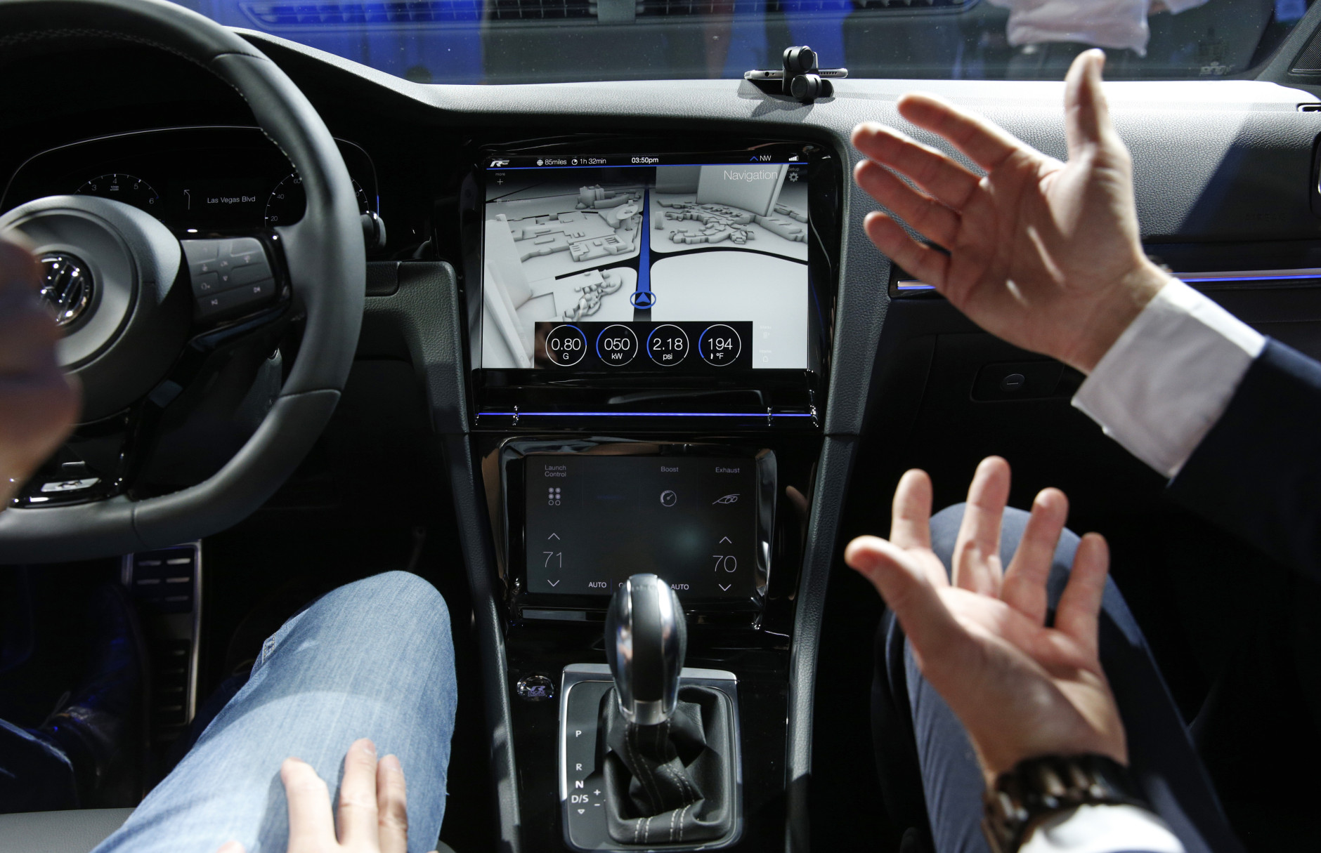 A Volkswagen employee shows off the touch screen in the Golf R Touch during a Volkswagen news conference at the International CES on Monday, Jan. 5, 2015, in Las Vegas. (AP Photo/John Locher)