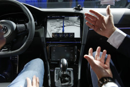 A Volkswagen employee shows off the touch screen in the Golf R Touch during a Volkswagen news conference at the International CES on Monday, Jan. 5, 2015, in Las Vegas. (AP Photo/John Locher)