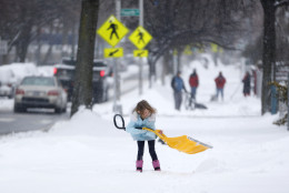 A young girl plays with a shovel following an overnight snowstorm, Tuesday, Jan. 27, 2015, in Jersey City, N.J.  A storm packing blizzard conditions spun up the East Coast early Tuesday, pounding coastal eastern Long Island into Maine with high winds and heavy snow.(AP Photo/Julio Cortez)