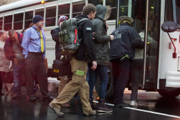 An FBI Medic, center, helps people onto a bus after they were evacuated from a smoke filled Metro subway tunnel in Washington, Monday, Jan. 12, 2015. Metro officials say one of the busiest stations in downtown Washington has been evacuated because of smoke.  Authorities say the source of the smoke is unknown.   (AP Photo/Jacquelyn Martin)