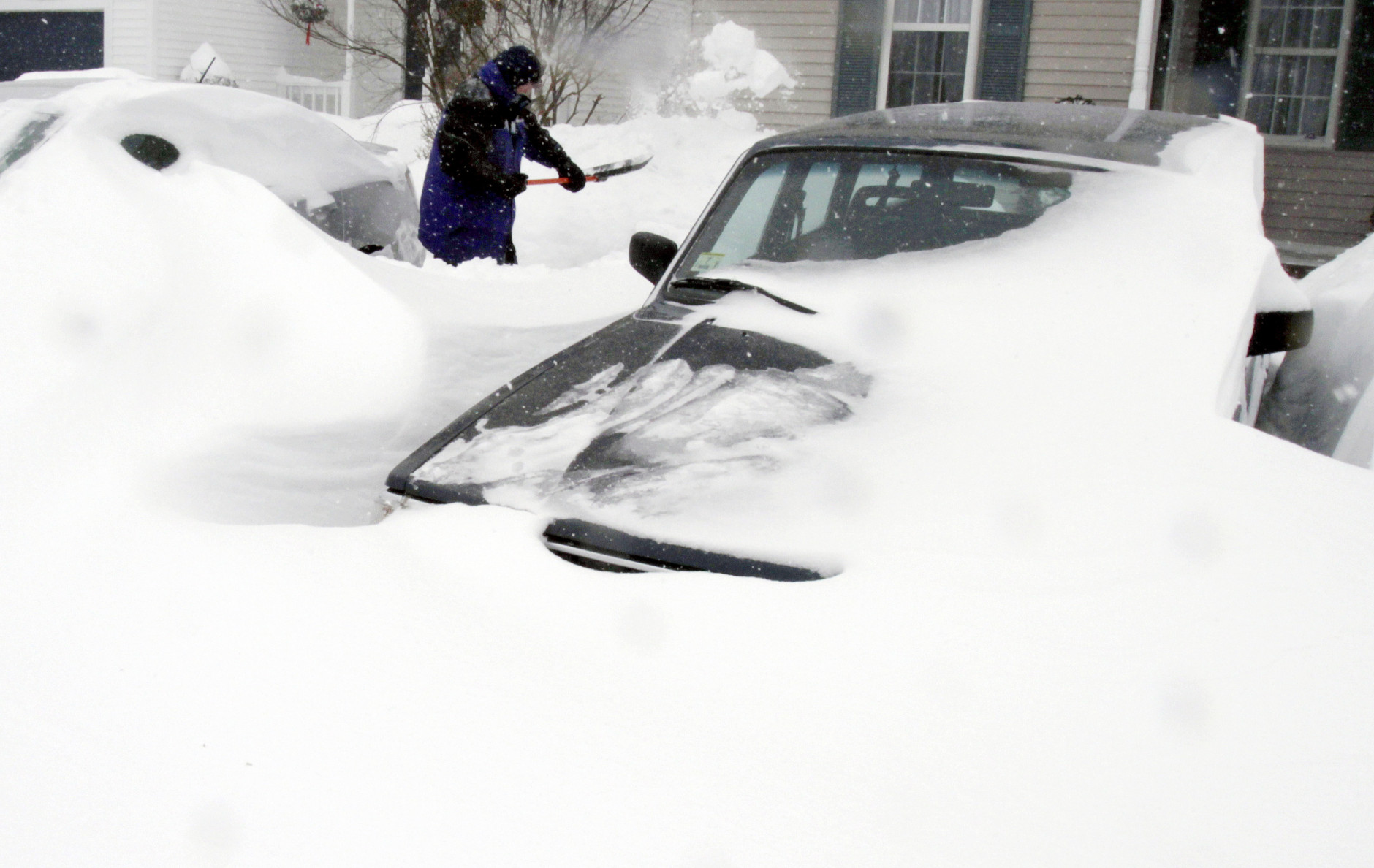Paul Baxter digs his cars out of drifted snow after a winter storm, Tuesday, Jan. 27, 2015, in Marlborough, Mass. A storm packing blizzard conditions spun up the East Coast early Tuesday, pounding parts of coastal New Jersey northward through Maine with high winds and heavy snow. (AP Photo/Bill Sikes)