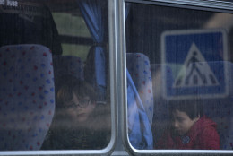 Children from the Henri Dunand school sit aboard a bus as they wait to be taken to a safe location to be picked up by their parents in Dammartin-en-Goele, 30 kilometers (19 miles) northeast of Paris, France, Friday Jan. 9, 2015. French security forces struggled with two rapidly developing hostage-taking situations Friday, one northeast of Paris where two terror suspects were holed up with a hostage in a printing plant and the other an attack on a kosher market in Paris. (AP Photo/Peter Dejong)