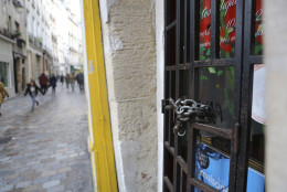 The iron gate of a shop is locked in the Rue des Rosiers street,  located in the heart of Paris Jewish quarter, in Paris, Friday Jan. 9, 2015. Police ordered all shops closed in a famed Jewish neighborhood in central Paris as Investigators are scrutinizing the recent past of two brothers with al-Qaida sympathies, as a manhunt for the suspects in the newsroom massacre at a satirical French weekly enters its third day. (AP Photo/Remy de la Mauviniere)