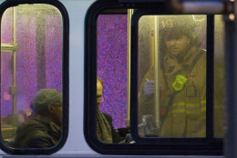 A firefighter attends people on a bus to assess triage needs after people were evacuated from a smoke filled Metro subway tunnel in Washington, Monday, Jan. 12, 2015. Metro officials say one of the busiest stations in downtown Washington has been evacuated because of smoke.  Authorities say the source of the smoke is unknown.  (AP Photo/Jacquelyn Martin)