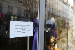 A sign at the door of a shop announces it is closed for the day, in the Rue des Rosiers street,  located in the heart of the Paris Jewish quarter, in Paris, Friday Jan. 9, 2015. Police ordered all shops closed in a famed Jewish neighborhood in central Paris, as Investigators are scrutinizing the recent past of two brothers with al-Qaida sympathies, as a manhunt for the suspects in the newsroom massacre at a satirical French weekly enters its third day. (AP Photo/Remy de la Mauviniere)