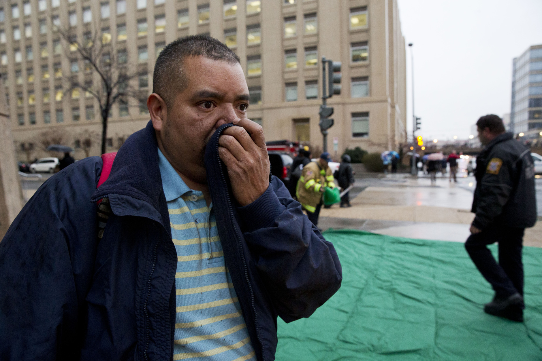 Reynaldo Hernandez holds a cloth over his smoke covered face as he coughs deeply after being evacuated from a smoke filled metro subway tunnel in Washington, Monday, Jan. 12, 2015.   Metro officials say one of the busiest stations in downtown Washington has been evacuated because of smoke.  Authorities say the source of the smoke is unknown.  (AP Photo/Jacquelyn Martin)