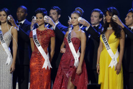 From left, Miss Colombia Paulina Vega, Miss Jamaica  Kaci Fennell, Miss Ukraine Diana Harkusha, and Miss Netherlands Yasmin Verheijen have their ears covered during a question and answer at the Miss Universe pageant in Miami, Sunday, Jan. 25, 2015. (AP Photo/Wilfredo Lee)