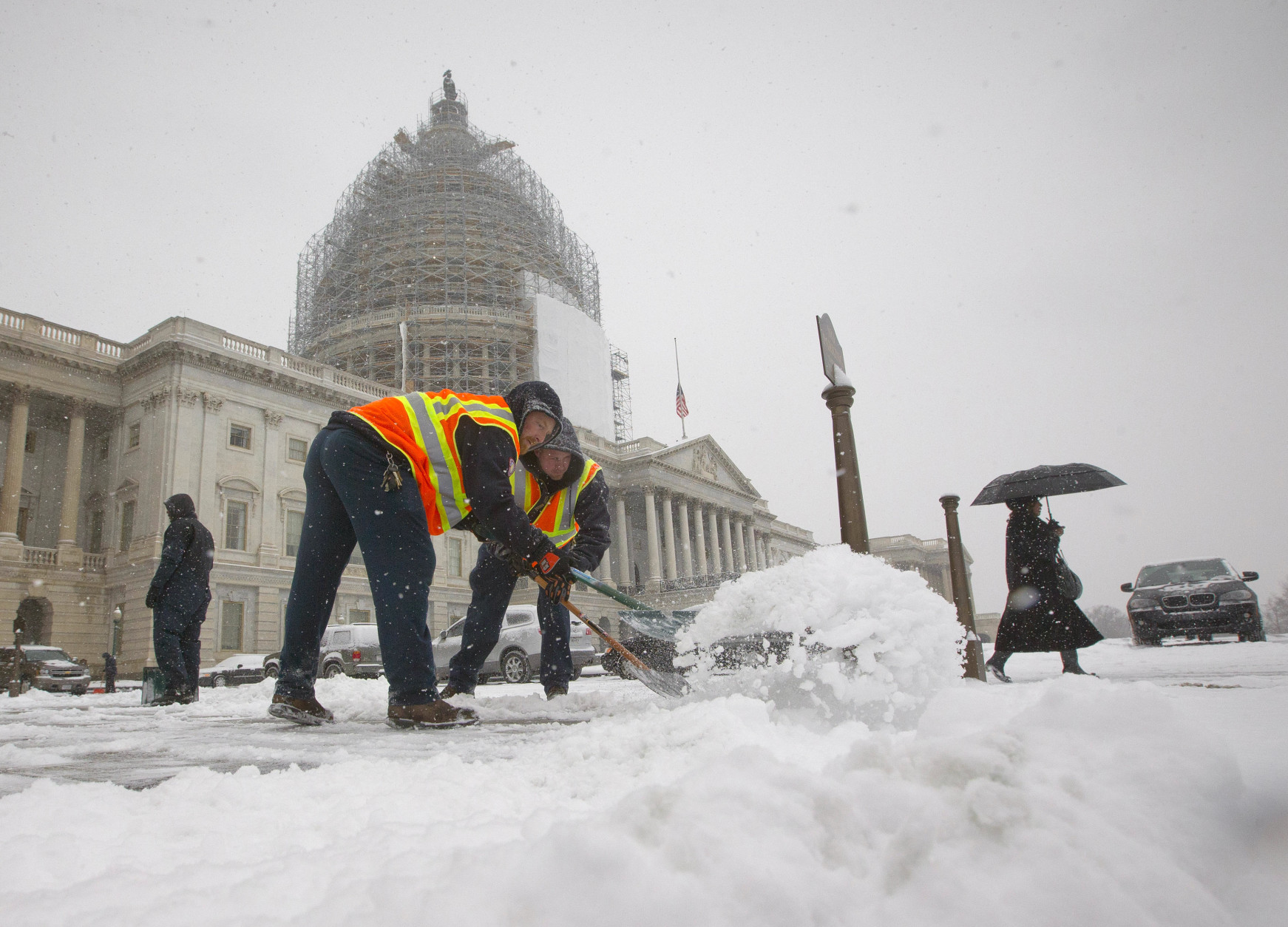 Workers clear the sidewalks of snow outside the U.S. Capitol, in Washington, Tuesday, Jan. 6, 2015. (AP Photo/Pablo Martinez Monsivais )