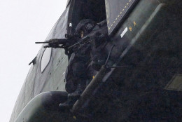 Armed security forces fly overhead in a military helicopter  in Dammartin-en-Goele, northeast of Paris, Friday Jan. 9, 2015.   French security forces swarmed this small industrial town northeast of Paris Friday in an operation to capture a pair of heavily armed suspects in the deadly storming of a satirical newspaper. (AP Photo/Thibault Camus)