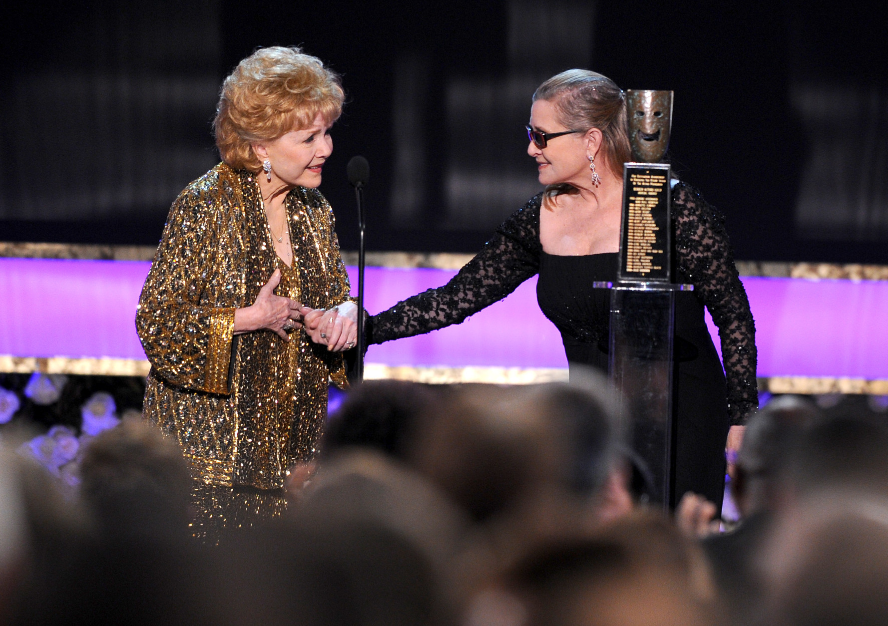 Carrie Fisher, right, presents Debbie Reynolds with the Screen Actors Guild life achievement award at the 21st annual Screen Actors Guild Awards at the Shrine Auditorium on Sunday, Jan. 25, 2015, in Los Angeles. (Photo by Vince Bucci/Invision/AP)