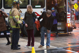 A couple holds hands as the man coughs while speaking with a firefighter after people were evacuated from a smoke filled Metro subway tunnel in Washington, Monday, Jan. 12, 2015. Metro officials say one of the busiest stations in downtown Washington has been evacuated because of smoke.  Authorities say the source of the smoke is unknown.   (AP Photo/Jacquelyn Martin)