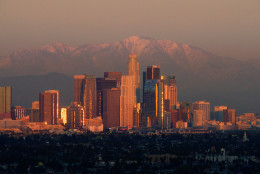 The sun sets over downtown Los Angeles skyline with the snow covered mountains behind it, Thursday, Jan. 3, 2013, in Los Angeles. (AP Photo/Mark J. Terrill)