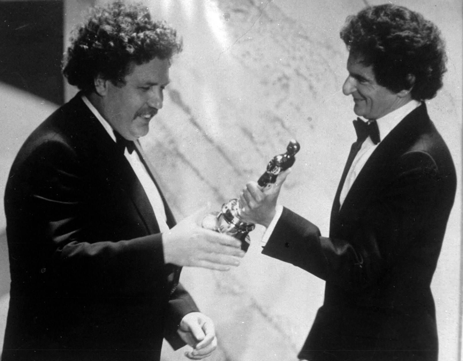 FILE - In this March 29, 1982 file photo, British actor and writer Colin Welland, left, accepts an Oscar for the best screenplay from Jerzy Kosinski, during the 54th annual Academy Awards presentation, Los Angeles. Actor and writer Colin Welland, who famously told Hollywood "the British are coming" when he won an Academy Award for "Chariots of Fire," has died aged 81. His family said in a statement Tuesday, Nov. 3, 2015 that Welland, who had suffered from Alzheimers disease, died peacefully in his sleep late Monday.  (AP Photo, File)