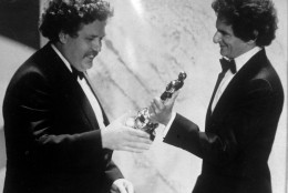 FILE - In this March 29, 1982 file photo, British actor and writer Colin Welland, left, accepts an Oscar for the best screenplay from Jerzy Kosinski, during the 54th annual Academy Awards presentation, Los Angeles. Actor and writer Colin Welland, who famously told Hollywood "the British are coming" when he won an Academy Award for "Chariots of Fire," has died aged 81. His family said in a statement Tuesday, Nov. 3, 2015 that Welland, who had suffered from Alzheimers disease, died peacefully in his sleep late Monday.  (AP Photo, File)