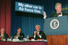 President Clinton holds a sign during the Radio and Television Correspondents Association annual dinner in Washington Thursday, March 21, 1996, as, from left, House Speaker Newt Gingrich, Vic Ratner of ABC Radio, and Dave McConnell, WTOP Radio, look on.  Attention at the dinner was focused on Clinton and Gingrich, who sat near each other on the dais and spoke back-to-back. (AP Photo/J.  Scott Applewhite)