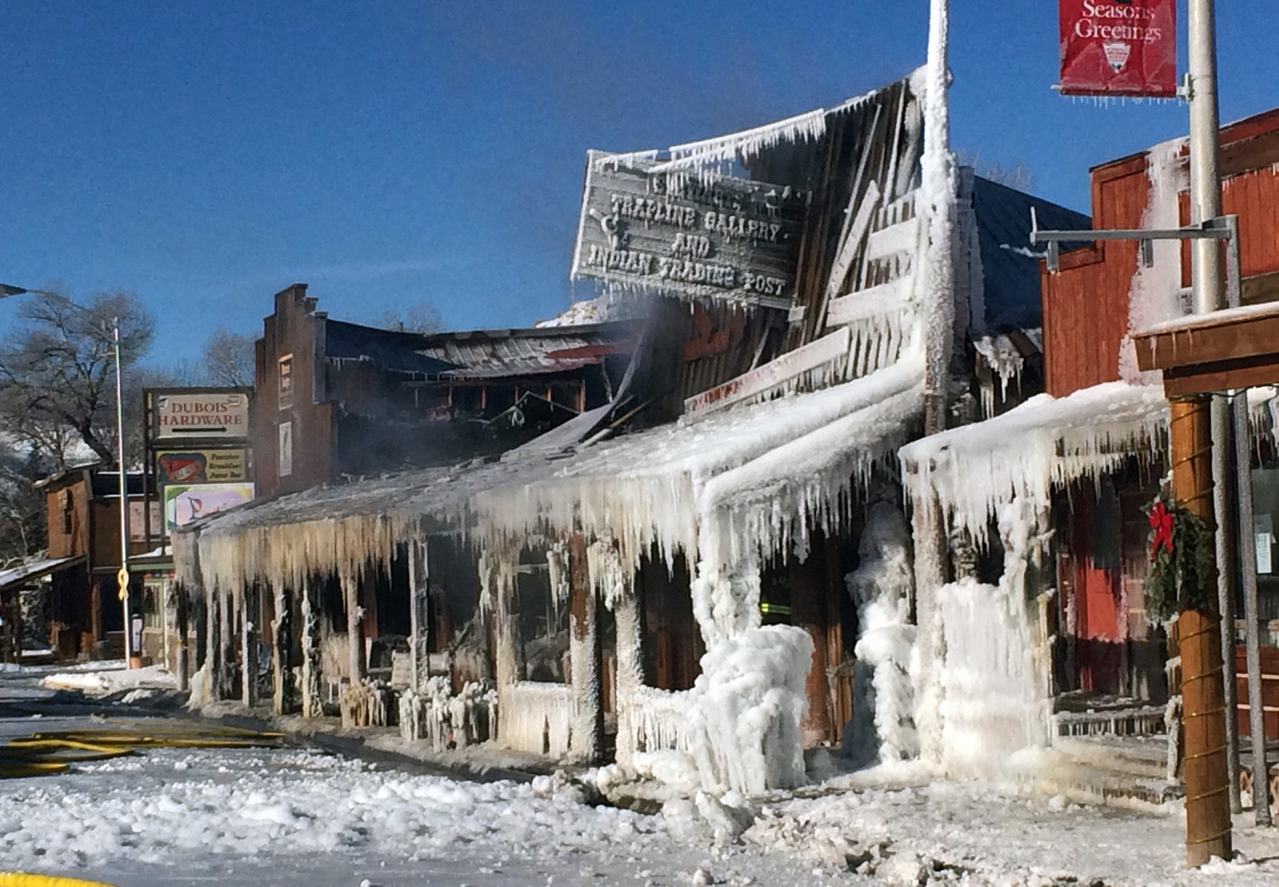 This Wednesday, Dec. 31, 2014 photo provided by Kate Wiltshire shows the frozen remains of building after a raging fire that swept through Dubois, Wyo. on Tuesday night. Huge flames ripped through the historic buildings in the picturesque western Wyoming town as firefighters contended with sub-zero temperatures that froze their hoses and other equipment. Four buildings containing more than a dozen businesses were destroyed, but Mayor Twila Blakeman credited firefighters with keeping the flames from spreading even further. (AP Photo/Kate Wiltshire)