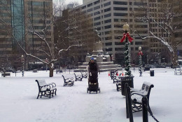 A couple pushes a stroller across Farragut Square in downtown D.C. after a snow storm on Jan. 6, 2015. (WTOP/Amanda Iacone)