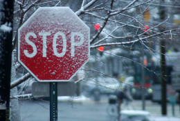 Snow sticks to a stop sign in Friendship Heights Monday, Jan. 26, 2015. (WTOP/Dave Dildine)