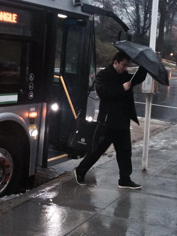 man gets off bus in rain