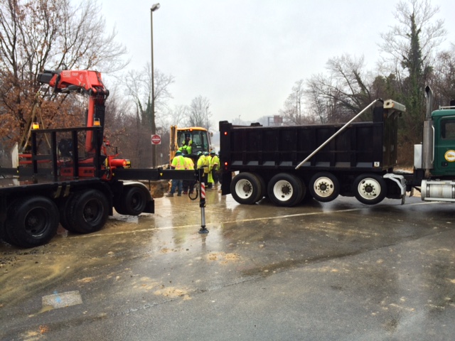 Men work to repair a water main break that occurred early Monday in Arlington on U.S. 29 at the bottom of the ramp from eastbound I-66 eastbound to Spout Run.  (WTOP/Rob Stallworth)