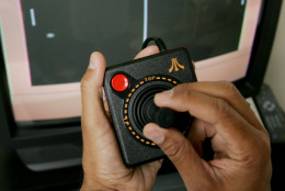 Associated Press writer Ron Harris uses the new Atari Flashback 2 video game console playing the game Pong in San Francisco, Thursday, Sept. 15, 2005. The Atari Flashback 2 recreates the classic home video gaming experience of decades past. Instead of requiring cartridges like the original Atari, Inc. console, these games are programmed in and offer a peek back at the good old days of Pong, Centipede, Asteroids and others. (AP Photo/Paul Sakuma)