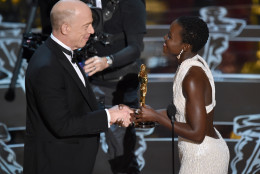 Lupita Nyong'o, right, presents J.K. Simmons with the award for best actor in a supporting role for Whiplash at the Oscars on Sunday, Feb. 22, 2015, at the Dolby Theatre in Los Angeles. (Photo by John Shearer/Invision/AP)