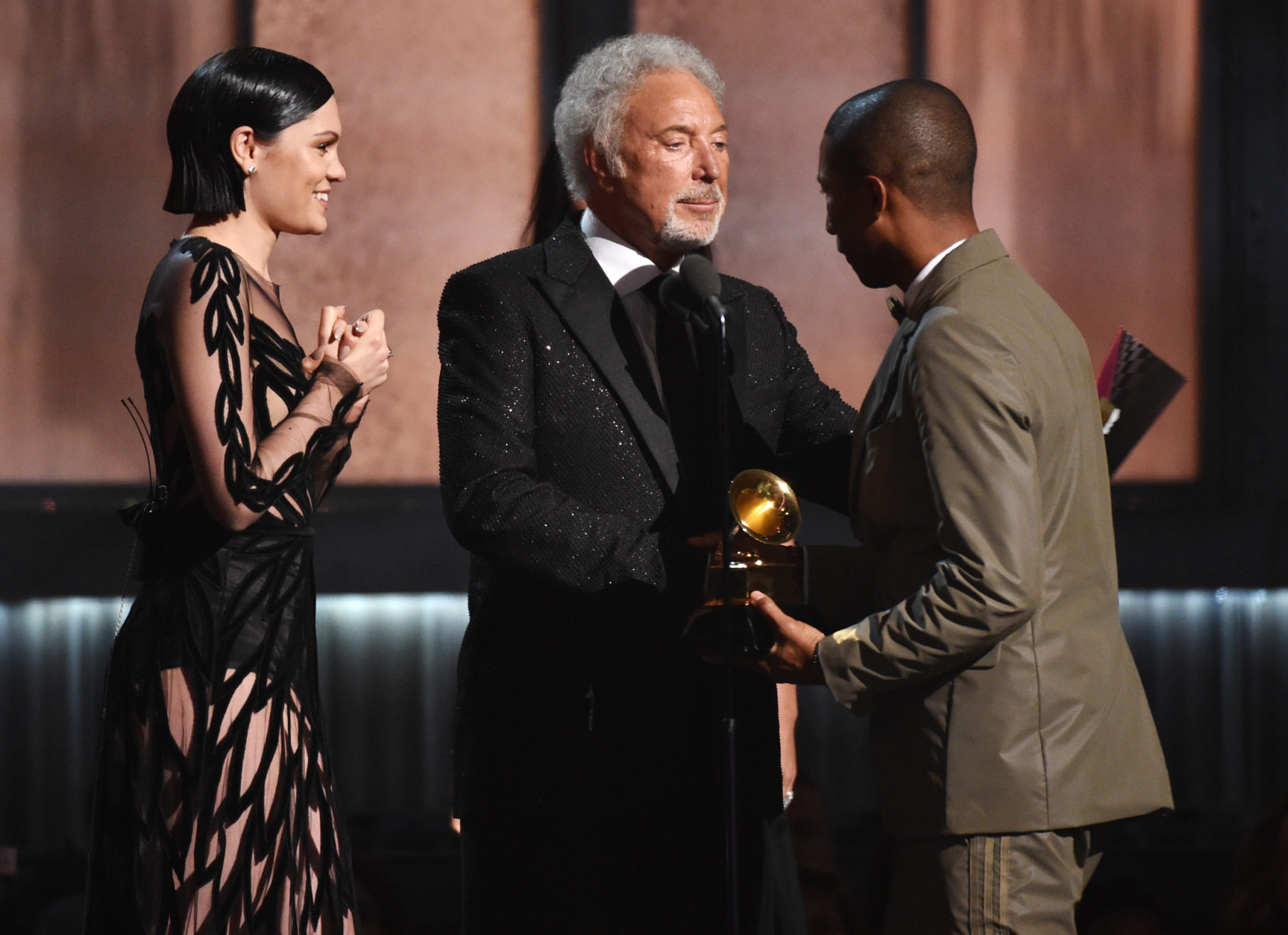 Jessie J, left, and Tom Jones present the award for best pop solo performance to Pharrell Williams, right, for "Happy" at the 57th annual Grammy Awards on Sunday, Feb. 8, 2015, in Los Angeles. (Photo by John Shearer/Invision/AP)