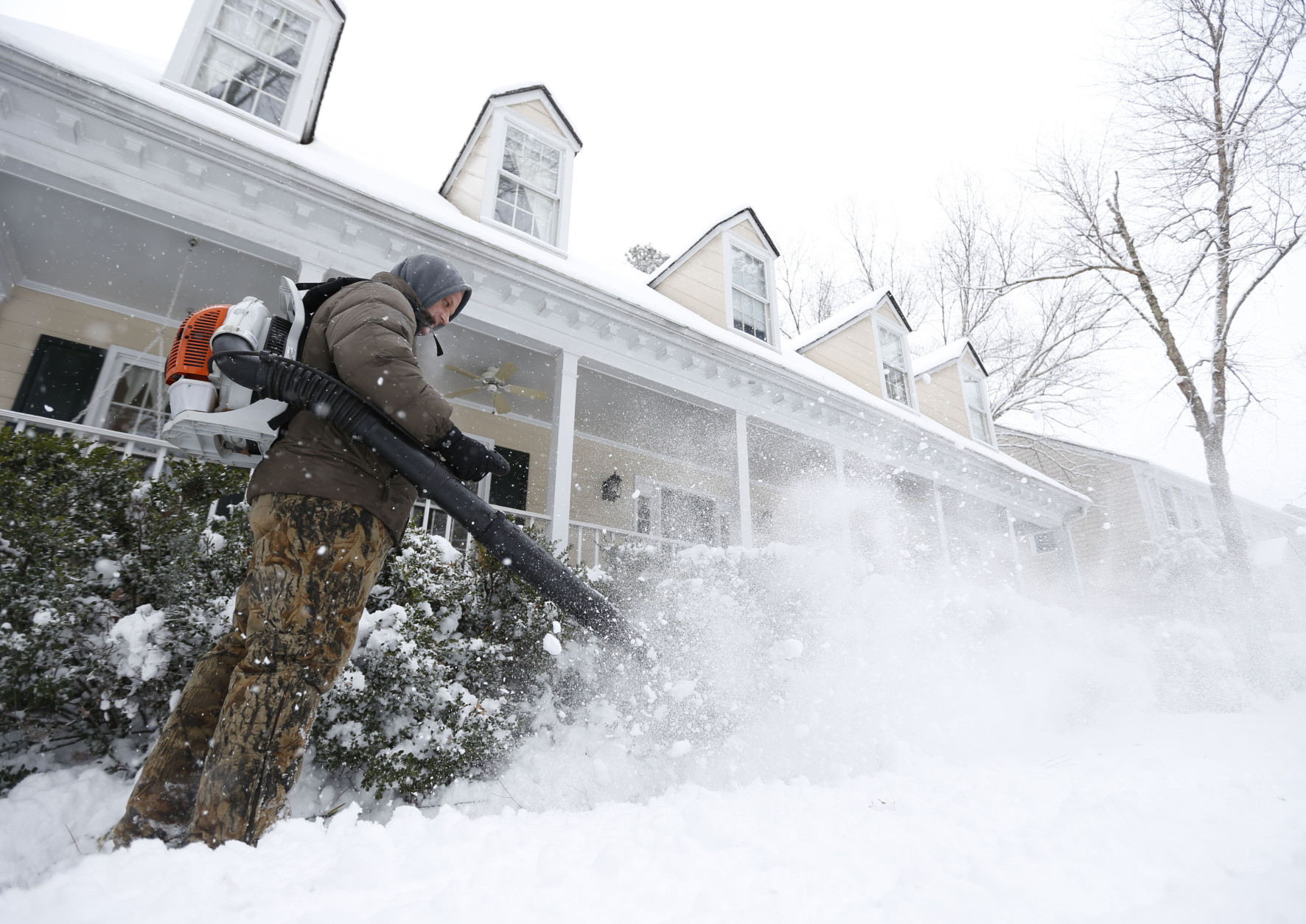 Breck Gorman of Richmond, Va., clears  the walkway in front of his home with a blower during a snowstorm in Richmond, Va., Thursday, Feb. 26, 2015. The Richmond area received about 4-6 inches of snow. (AP Photo/Steve Helber)