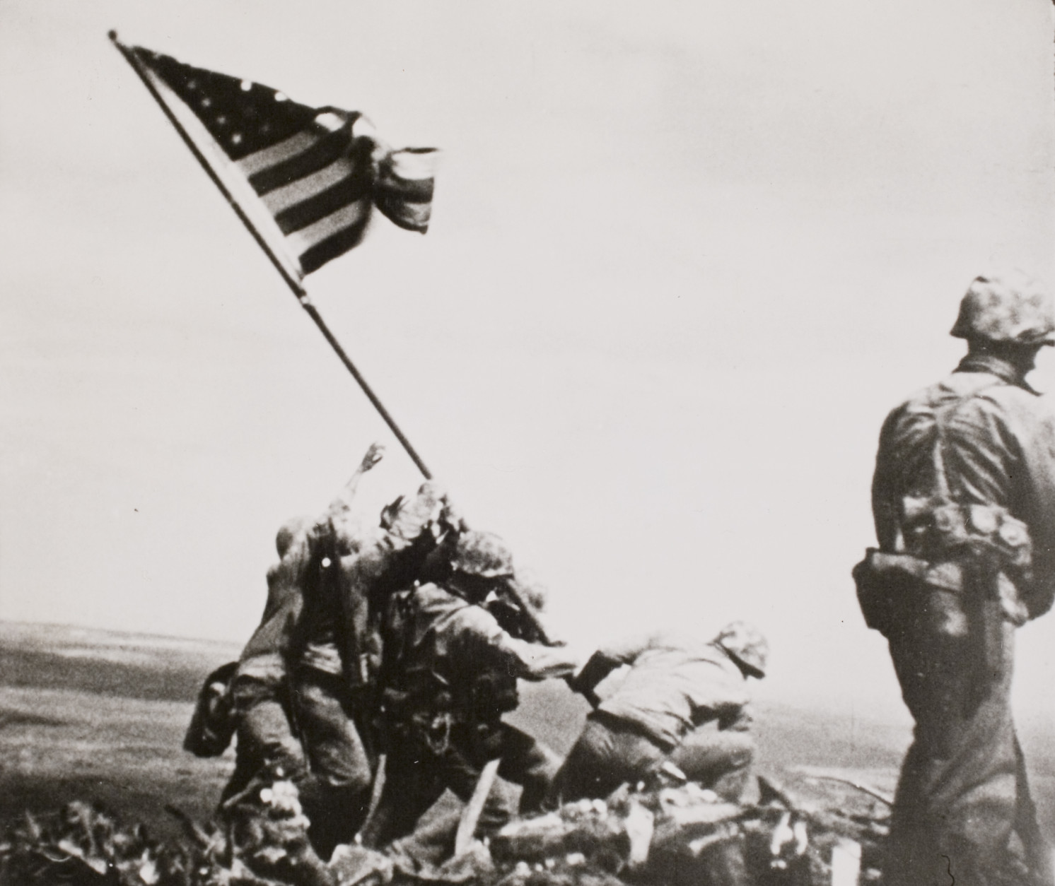 This black-and-white image provided by the National Archives shows a "still" taken from the 16 mm movie series of Marines raising the American flag on the summit of Mount Suribachi, on Iwo Jima. (AP Photo/Files/William H. Genaust)