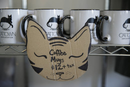 In this photo taken Thursday, Nov. 6, 2014, coffee mugs are shown for sale at the Cat Town Cafe in Oakland, Calif. Following similar concepts in Asia &amp; Europe, the cafe has become America's first permanent feline-friendly coffee shop. Cafe customers pay to pet cute kitties while sipping on tea or expresso drinks. It allows customers, who may not be able to have cats in their own homes, to enjoy the benefits of furry friends for short times without the responsibility. The animals come from a partnership with a local animal shelter and are also available for adoption. Similar cafes are planned to open soon in Seattle, Portland, San Diego and Denver. (AP Photo/Eric Risberg)