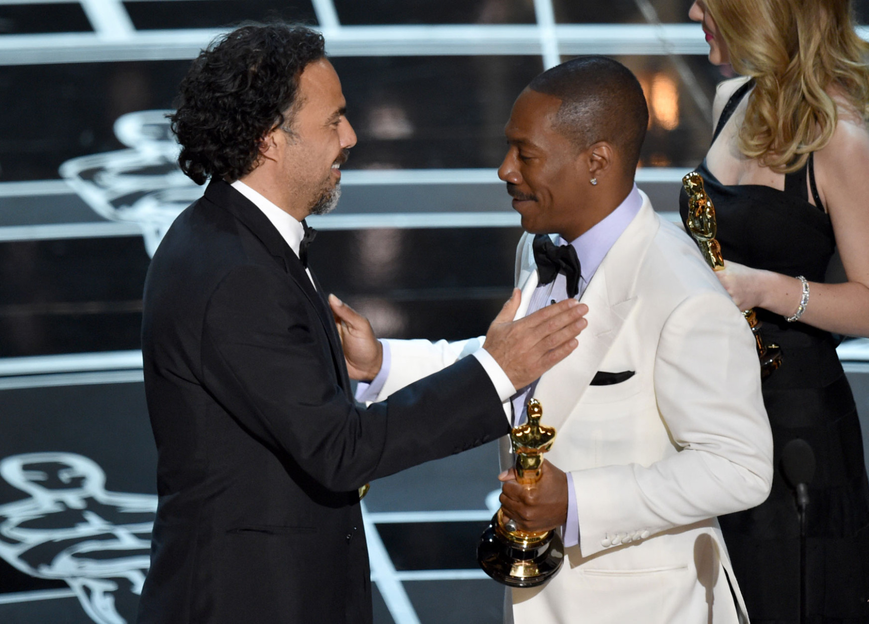 Eddie Murphy, right, presents Alejandro G. Inarritu with the award for the best original screenplay for “Birdman or (The Unexpected Virtue of Ignorance)” at the Oscars on Sunday, Feb. 22, 2015, at the Dolby Theatre in Los Angeles. (Photo by John Shearer/Invision/AP)