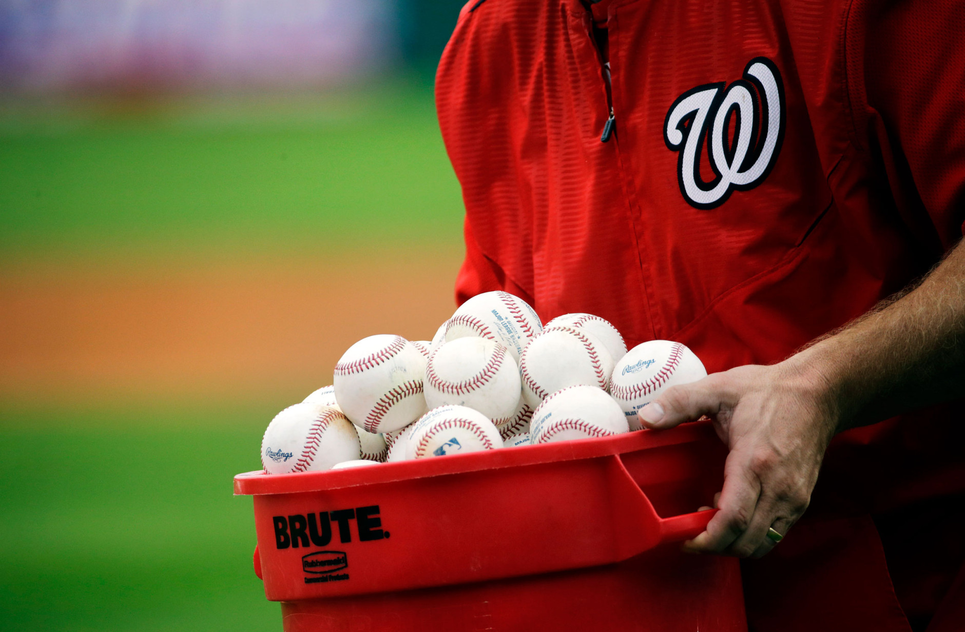 A bucket of baseballs is carried onto the field by Washington Nationals third base coach Bob Henley during a spring training baseball workout, Wednesday, Feb. 25, 2015, in Viera, Fla. (AP Photo/David Goldman)