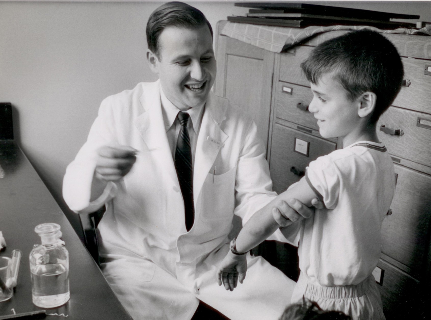 Here, Dr. Samuel Katz injects one of his sons with the measles vaccine.