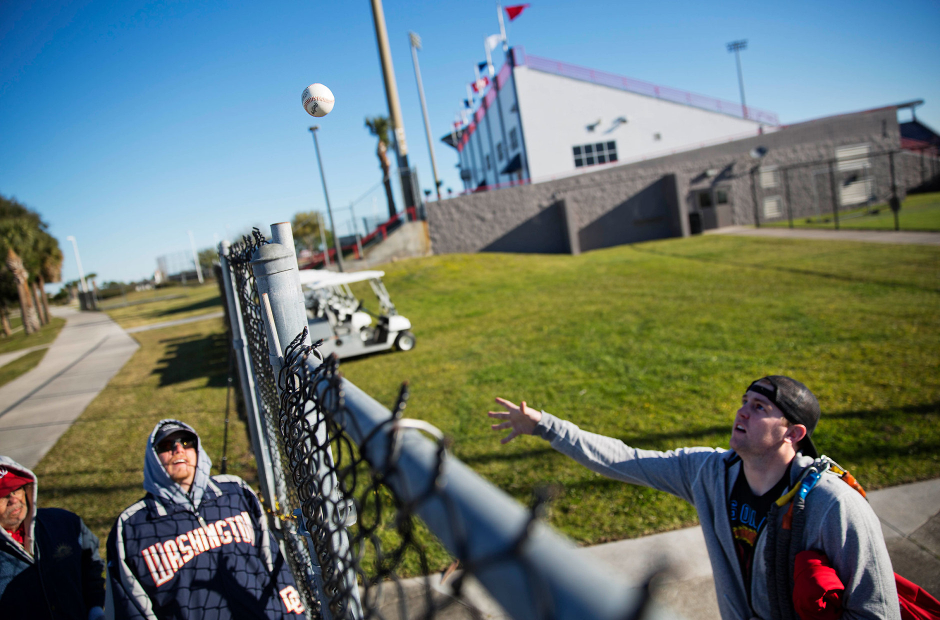 Washington Nationals pitcher Drew Storen, right, tosses a ball over the fence after autographing it for fans as pitchers and catchers officially report to the team's spring training baseball facility, Thursday, Feb. 19, 2015, in Viera, Fla. (AP Photo/David Goldman)