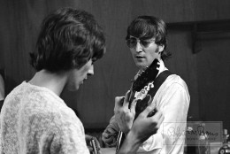 John Lennon tunes his 1966 Epiphone Casino guitar while George Harrison assists with a harmonica in this candid backstage photograph taken before the Beatles’ show at JFK Stadium (formerly Philadelphia Municipal Stadium) in Philadelphia, Pennsylvania, on August 16, 1966. The show was far from a sell-out, like many of the shows on this tour, thanks in part to John Lennon’s incendiary out-of-context comment: “We’re more popular than Jesus.” John’s six-string guitar, similar to one that George also had, was a staple on their 1966 world tour, as well as on the Revolver album and the song Paperback Writer/Rain. Indeed, it was in John’s hands for their final official live show in San Francisco, and most famously at their final live show ever - an impromptu rooftop performance at Apple Records’ Saville Row offices in London. Sometime before the Sgt. Pepper’s Lonely Hearts Club Band sessions, John spray-painted the back of his guitar, but would later sand it down to its bare wood (which George claimed really allowed instruments to “breathe”). The Casino was John’s guitar of choice until the end, seeing him through the White Album, Let It Be, as well as onscreen in various promos for Hello Goodbye, Hey Jude and Revolution. This guitar held a special place in John’s heart, and in his estate as “The Revolution Guitar.”