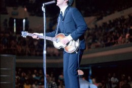 A serene crooning Paul McCartney is juxtaposed with a beyond-littered stage in this photo taken during an August 19, 1965, show at the Sam Houston Coliseum in Houston, Texas. The Beatles played two sold-out shows in Houston, advertised as the “Sixth Annual Back-to-School Show,” to capacity crowds of 9,200 screaming fans with general admission seating. Predominantly teenage girls suffering from Beatlemania (thanks to the recent release of the film HELP!), began tossing jellybeans on stage because George Harrison had mentioned he loved the softer (and totally unavailable) British version, jelly babies, in an interview. Along with a barrage of hard candy, fans threw paper, cups and even a few dangerous objects. Entertainment reporter Jeff Millar noted, “Nobody missed a note as cups caromed off their faces. George Harrison adroitly dodged the largest object hurled, apparently someone’s right tennis shoe.” But it was John Lennon who pithily summed up their second US tour so far: “We’ve only been to Dallas and here. And we almost got killed both places.” 

