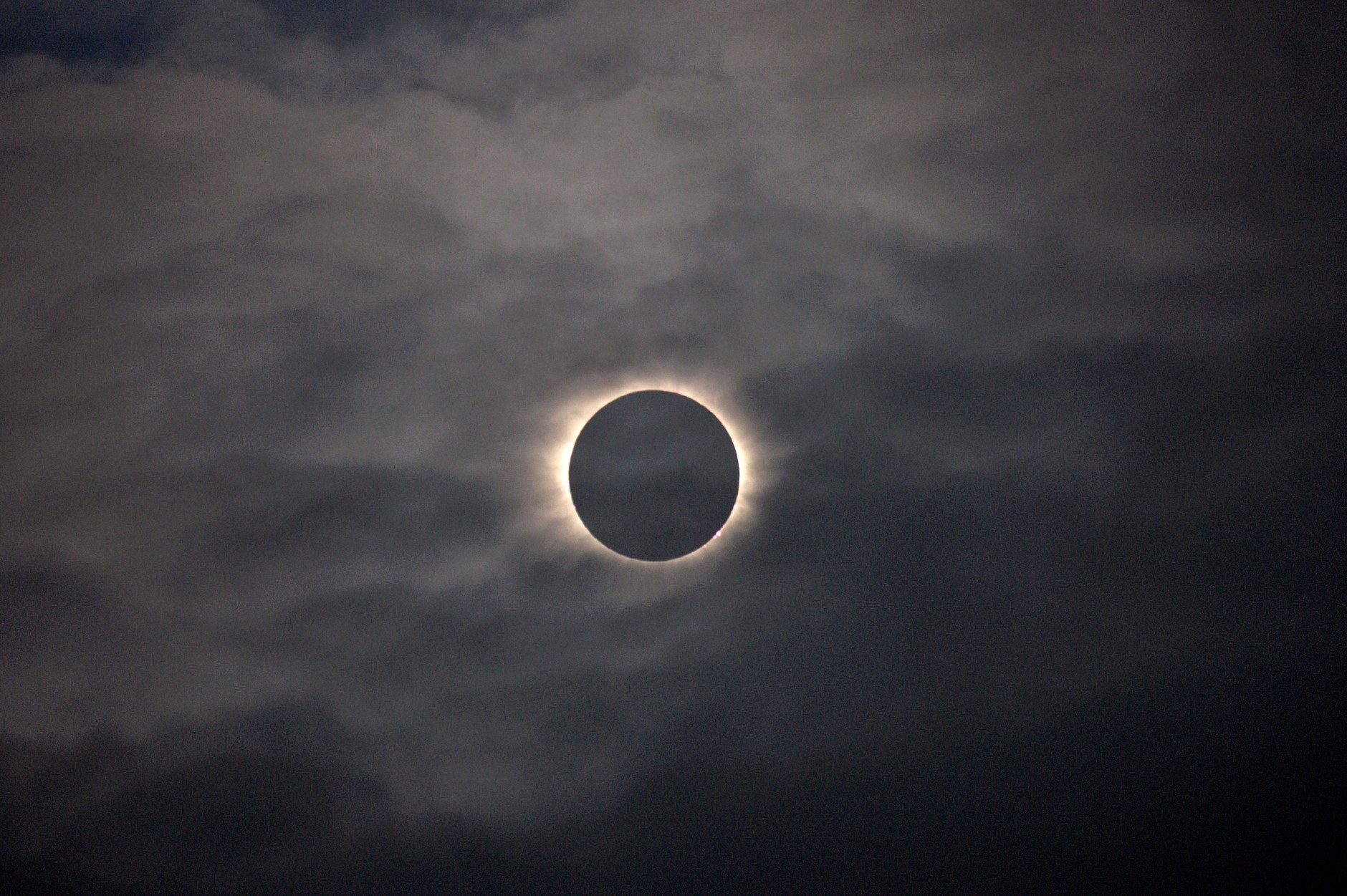 A total solar eclipse is visible through the clouds as seen from Vagar on the Faeroe Islands, Friday, March 20, 2015.  Apart from a few small breaks, a blanket of clouds in the Faeroe Islands blocked thousands of people there from experiencing the full effect of the total eclipse.  (AP Photo/Eric Adams)