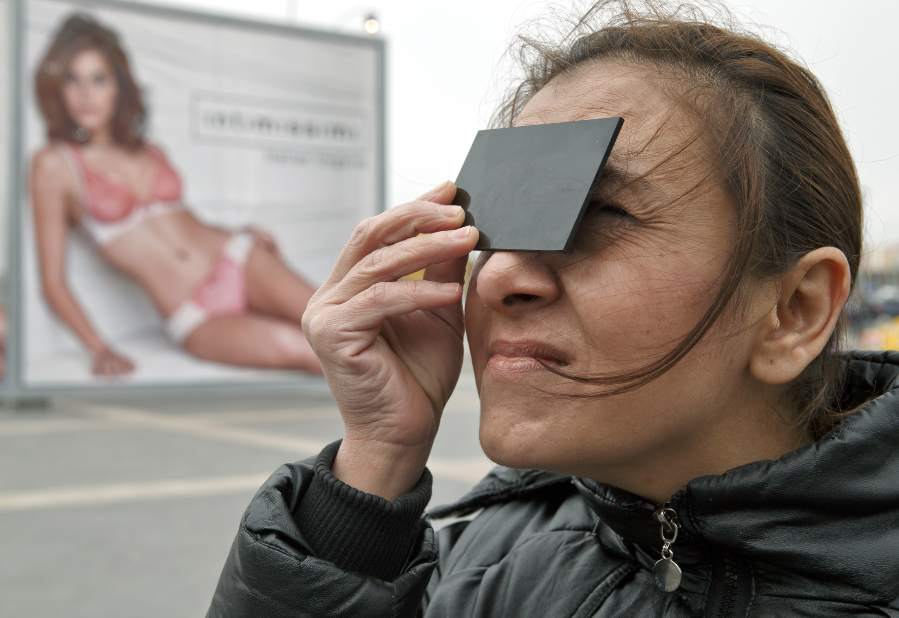 A woman uses tinted glass to watch a solar eclipse through a telescope outside a shopping mall in Bucharest, Romania, Friday, March 20, 2015. Clouds obscured the sun for most of the time the eclipse took place. (AP Photo/Vadim Ghirda)