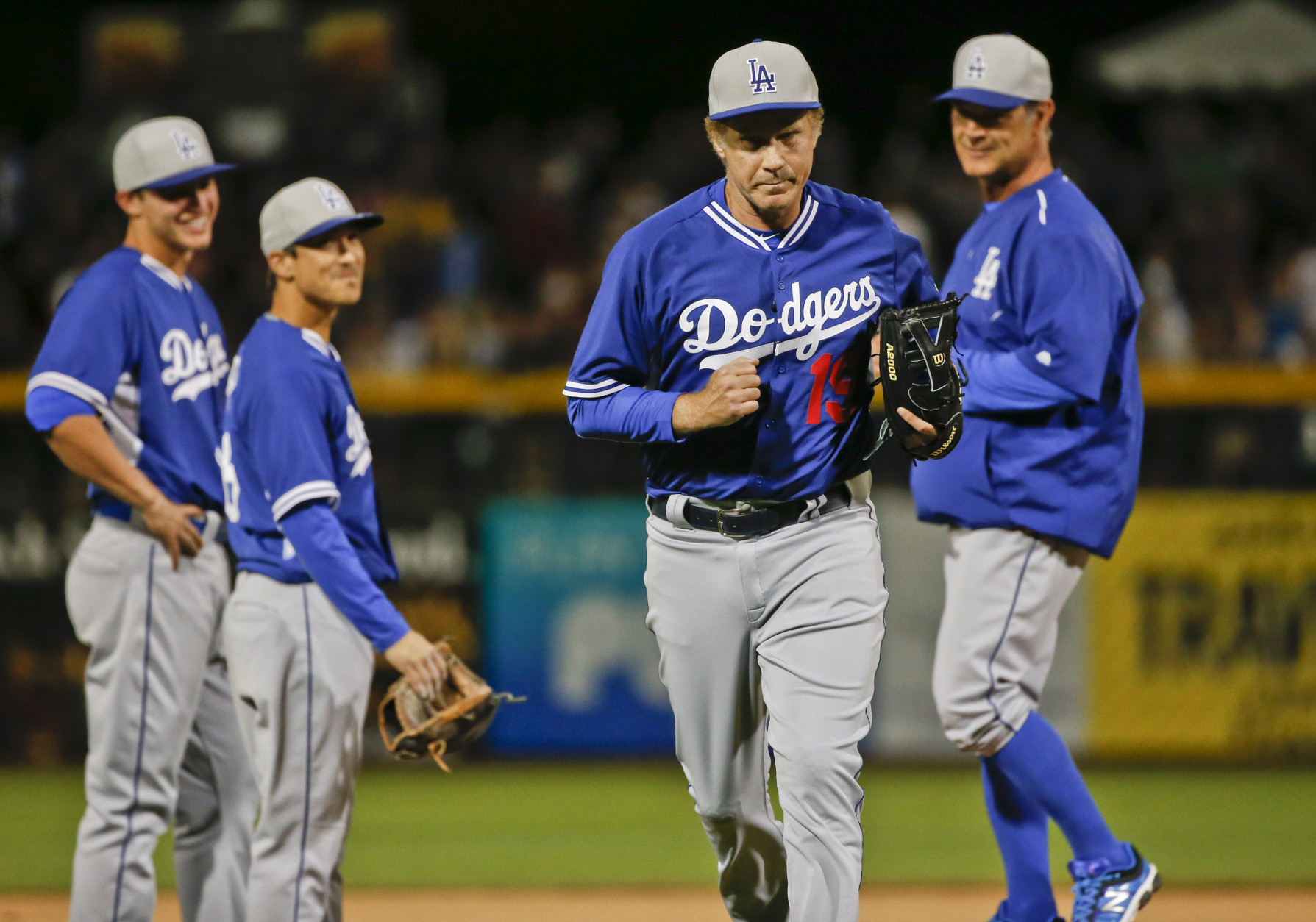 Actor Will Ferrell jogs from the pitcher's mound after being removed from the game by Los Angeles Dodgers manager Don Mattingly, right, during a spring training baseball game between the San Diego Padres and the Dodgers Thursday, March 12, 2015, in Peoria, Ariz. (AP Photo/Lenny Ignelzi)