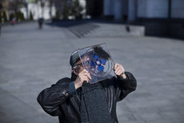 A man uses a piece of tinted glass to observe a solar eclipse in Belgrade, Serbia, Friday, March 20, 2015. Astronomy lovers and sky gazers in Serbia were treated to a clear blue sky as they observed a solar eclipse in Belgrade on Friday. (AP Photo/Marko Drobnjakovic)
