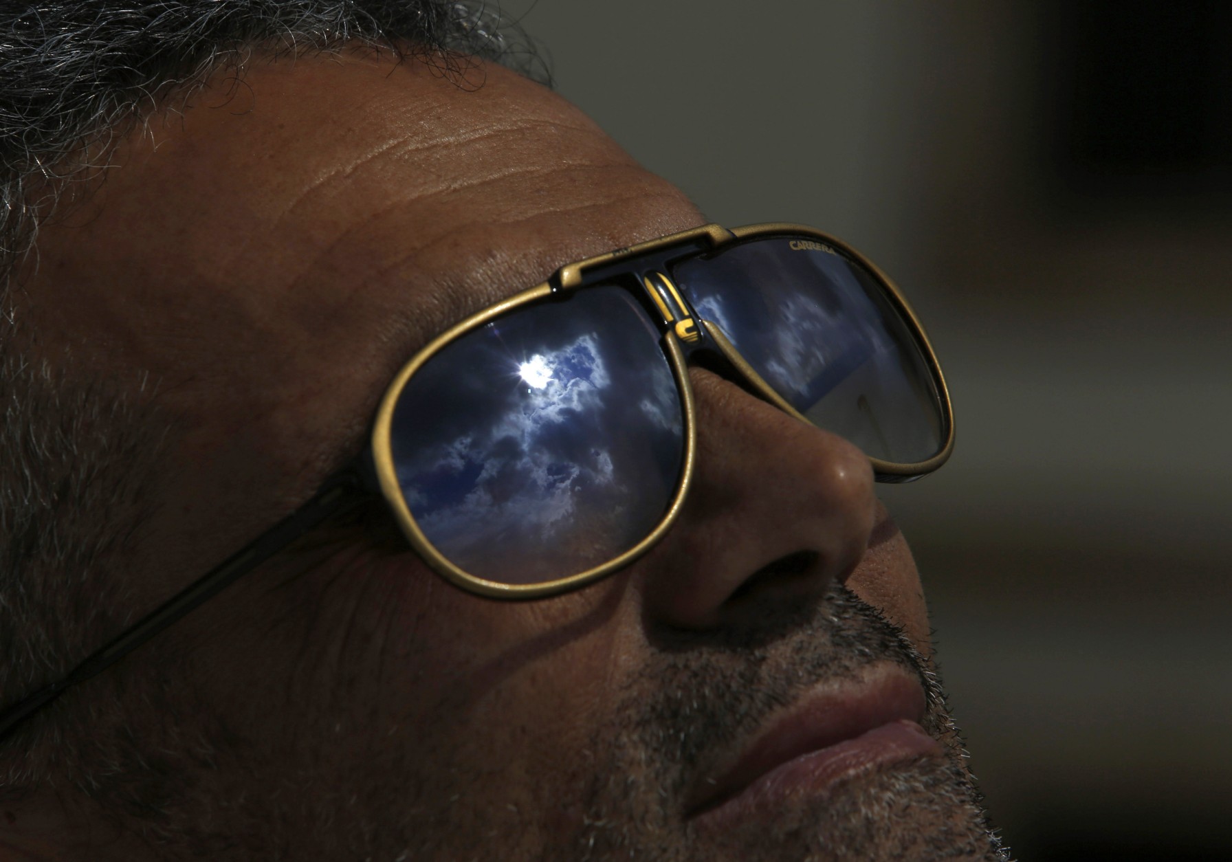 The solar  eclipse is reflected on the sunglasses of a man in  Nicosia, Cyprus, Friday, March 20, 2015. An eclipse is darkening parts of Europe on Friday in a rare solar event that won't be repeated for more than a decade. (AP Photo/Petros Karadjias)
