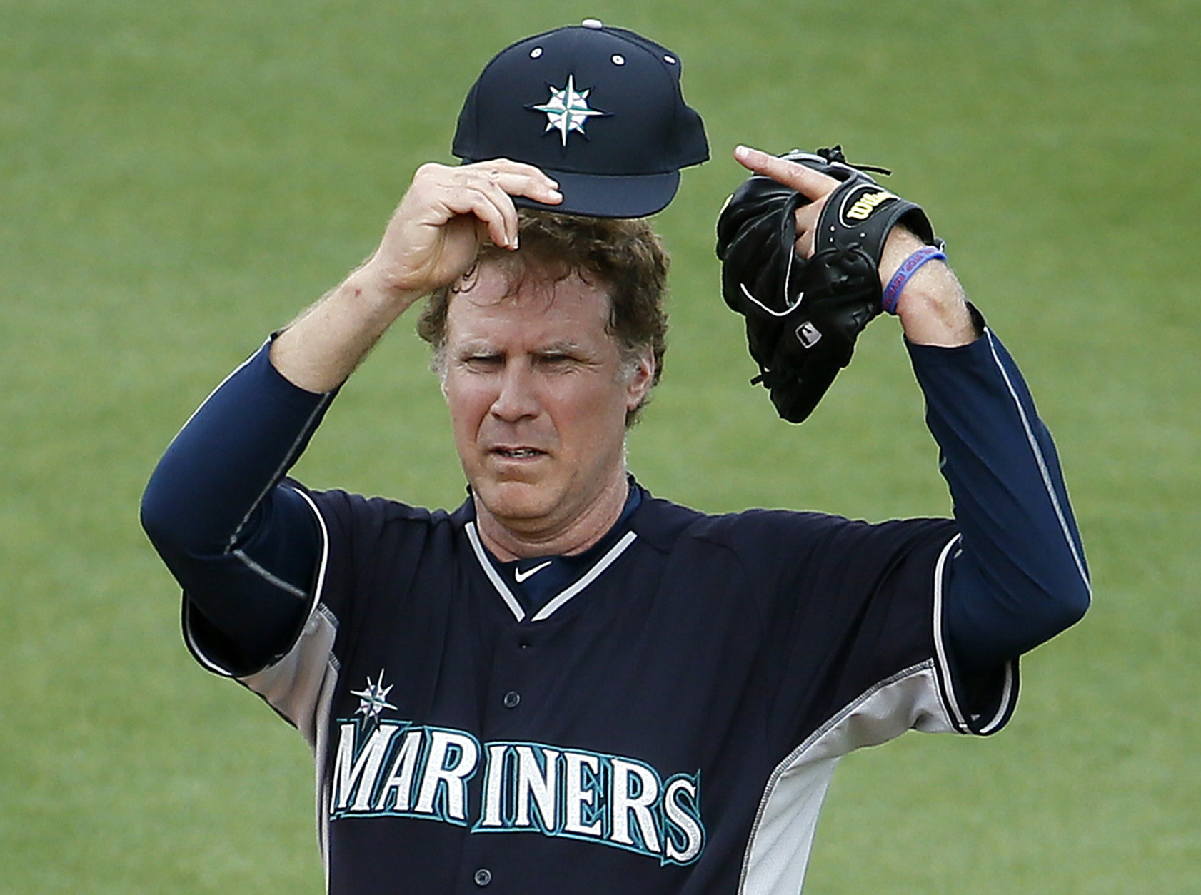 Actor Will Ferrell shows off his cap as he plays second base for the Seattle Mariners during the second inning of a spring training baseball game against the Oakland Athletics, Thursday, March 12, 2015, in Mesa, Ariz. The comedian plans to play every position while making appearances at five Arizona spring training games on Thursday. (AP Photo/Matt York)